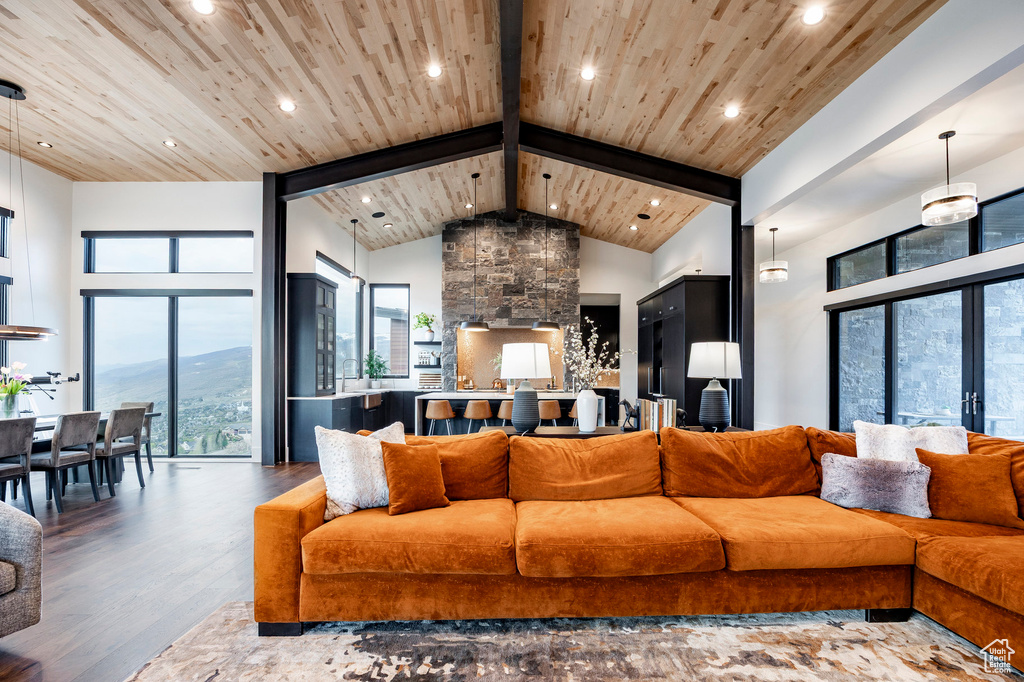 Living room with a wealth of natural light, wooden ceiling, and wood finished floors