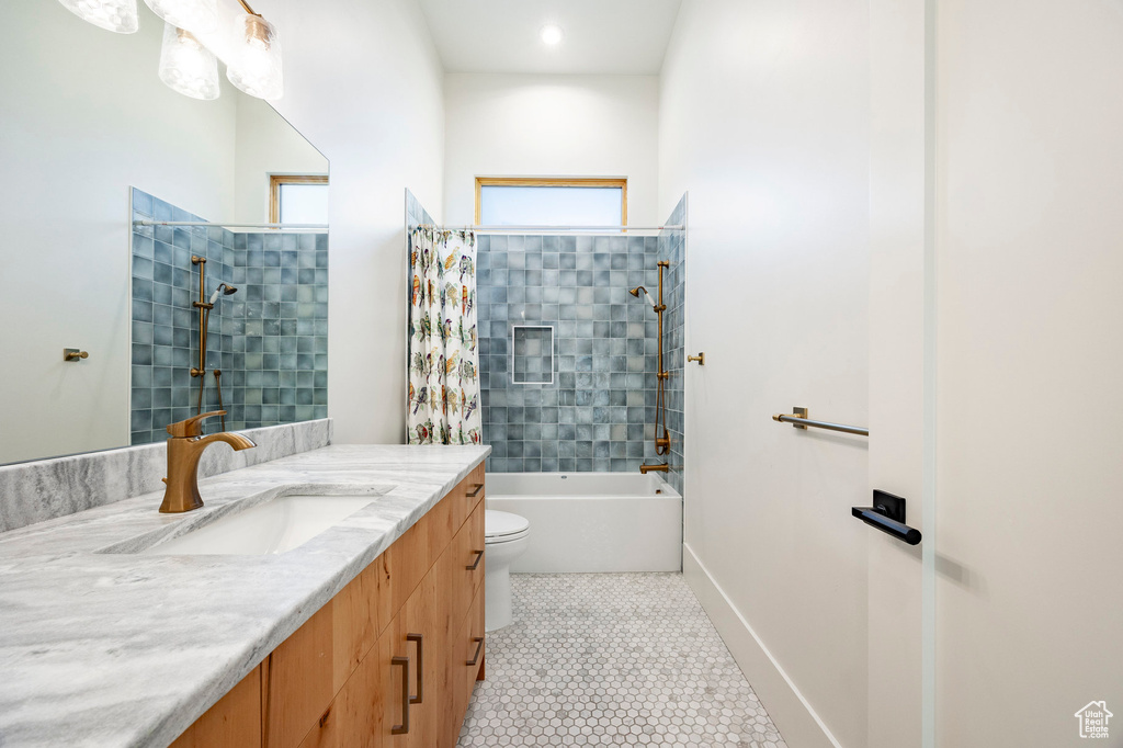 Bathroom featuring vanity, tub / shower combination, toilet, and a healthy amount of sunlight
