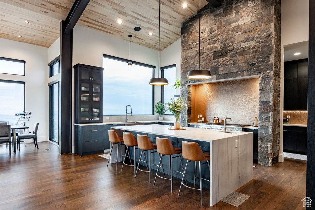 Kitchen featuring wooden ceiling, light countertops, high vaulted ceiling, and a large island