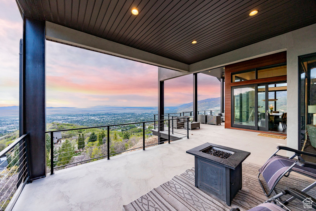 Patio terrace at dusk with a fire pit and a mountain view