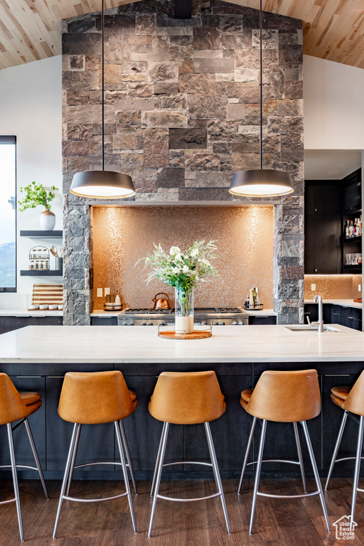 Bar featuring wooden ceiling, dark wood-style flooring, lofted ceiling, and a sink