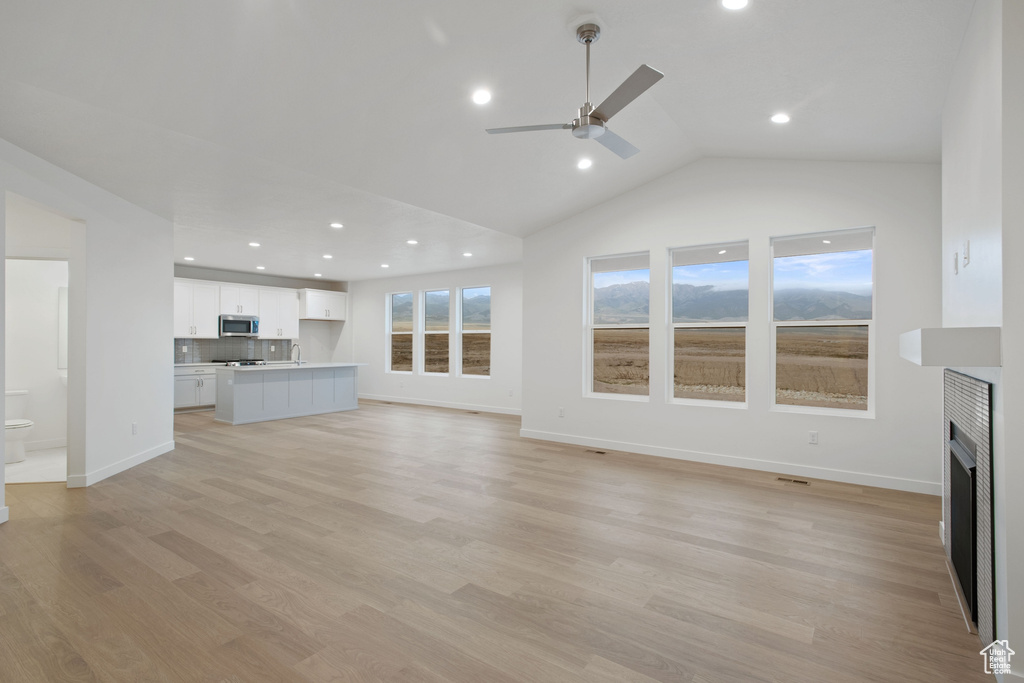 Unfurnished living room with recessed lighting, a fireplace, vaulted ceiling, a ceiling fan, and baseboards