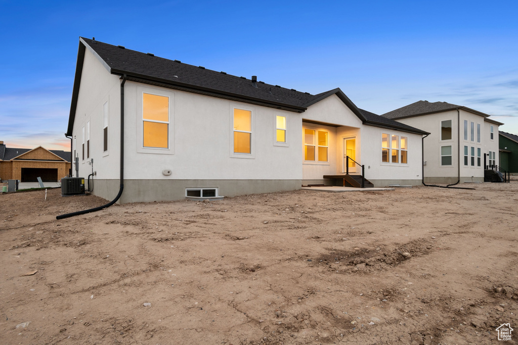 Rear view of property featuring central air condition unit and stucco siding