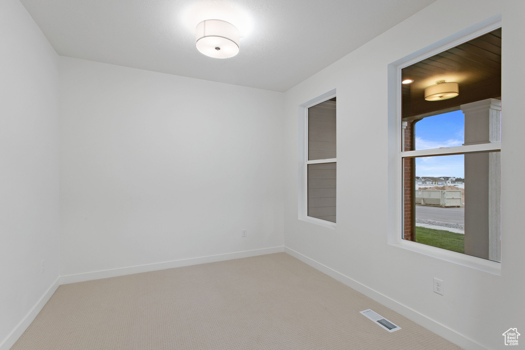 Unfurnished room with visible vents, baseboards, and carpet floors