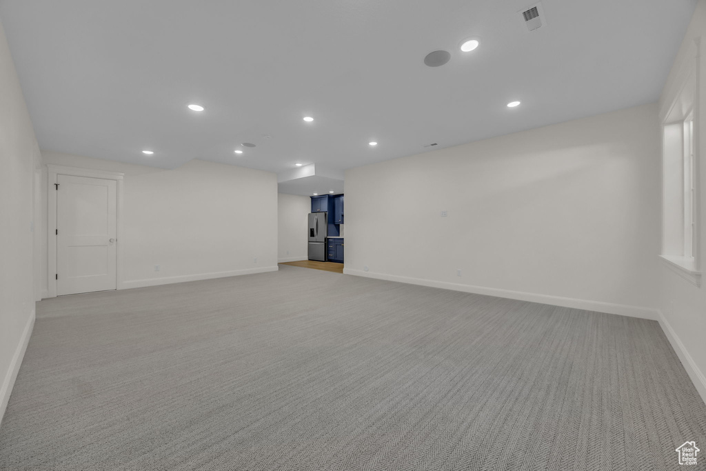 Interior space featuring baseboards, visible vents, recessed lighting, and light colored carpet