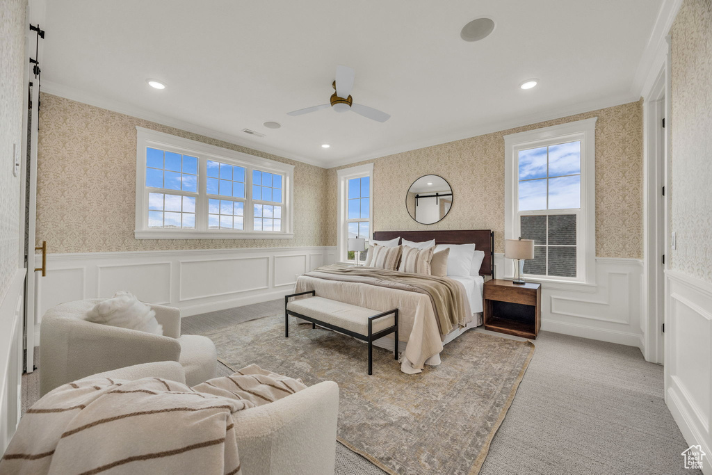 Carpeted bedroom with wallpapered walls, crown molding, a wainscoted wall, a decorative wall, and recessed lighting
