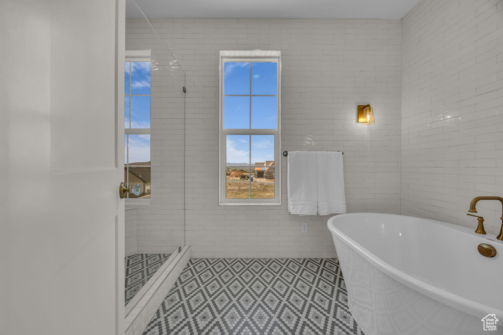 Full bath featuring a stall shower, tile patterned floors, and a freestanding bath