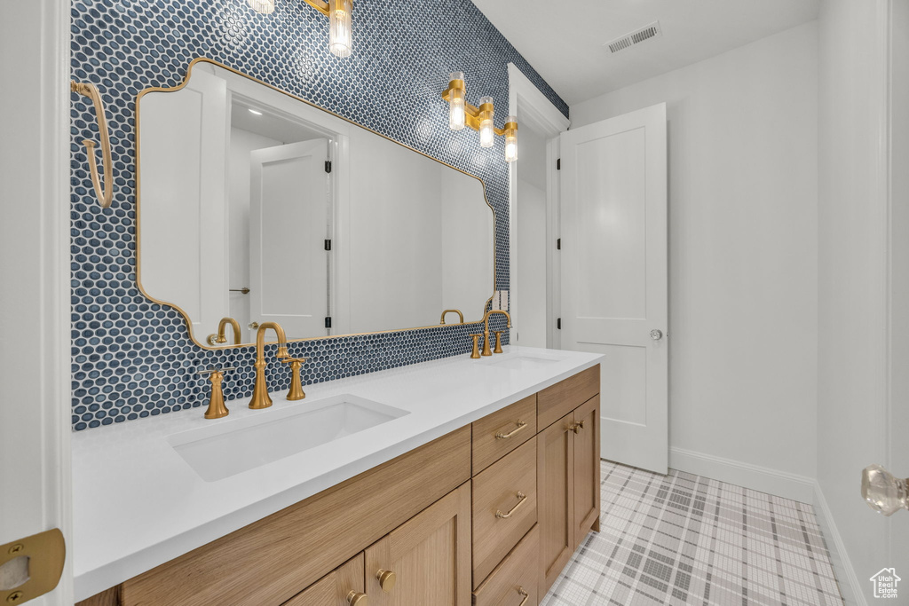 Bathroom with baseboards and double vanity