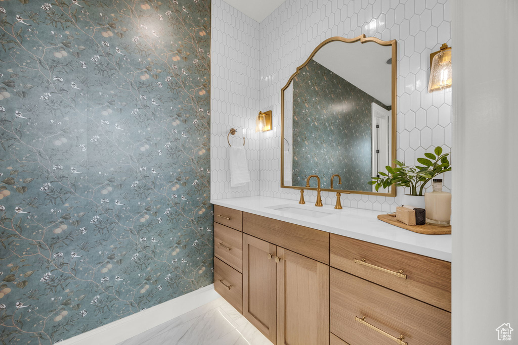 Bathroom featuring vanity and tasteful backsplash