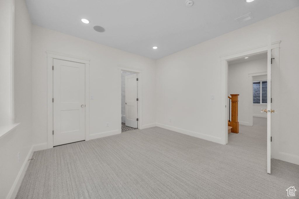 Empty room with light colored carpet, baseboards, and recessed lighting