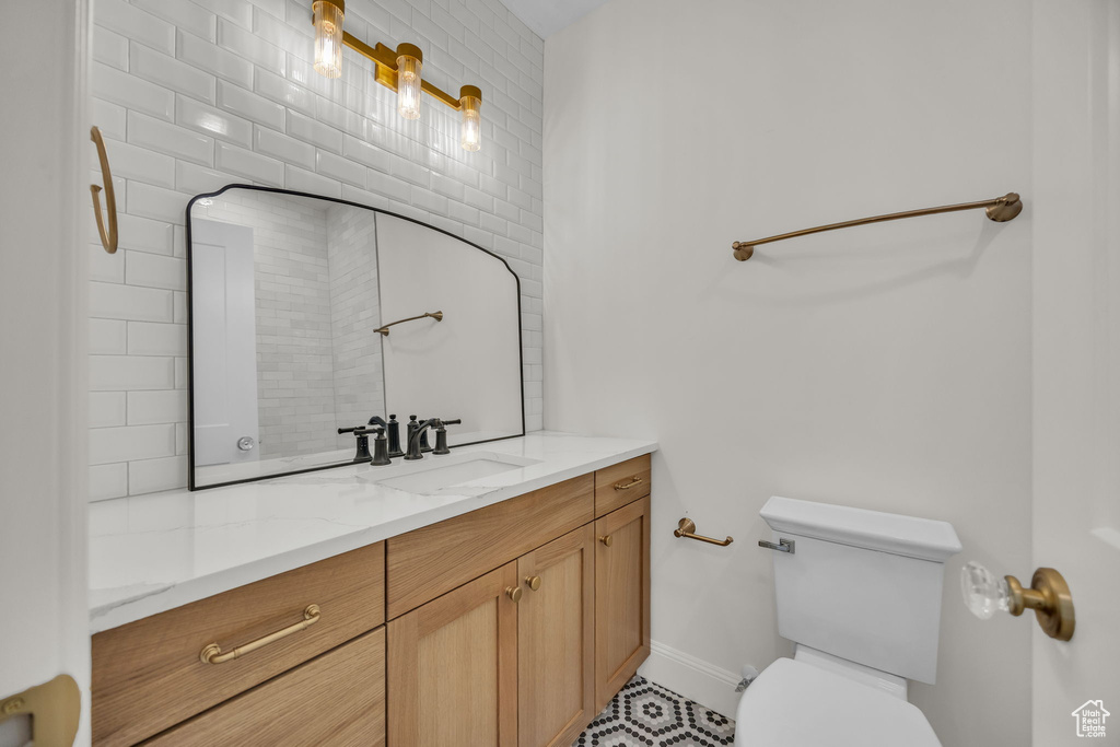 Bathroom with vanity, toilet, and baseboards
