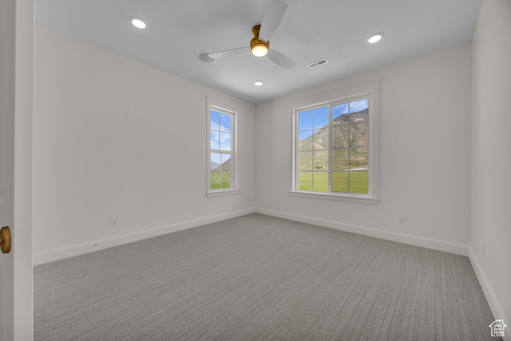 Spare room with carpet, a ceiling fan, visible vents, baseboards, and recessed lighting