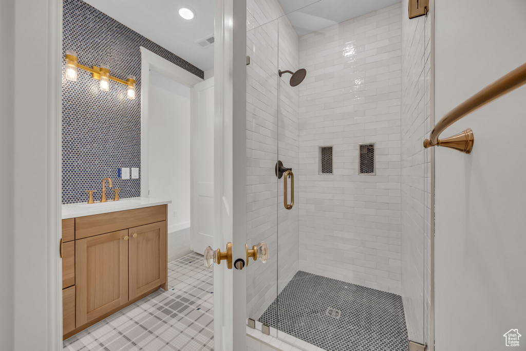 Full bathroom with tile patterned floors, vanity, visible vents, and a stall shower