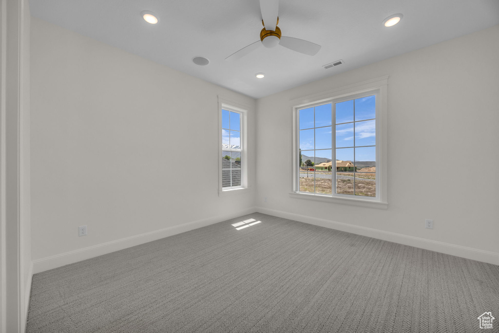 Carpeted spare room featuring baseboards, ceiling fan, recessed lighting, and visible vents