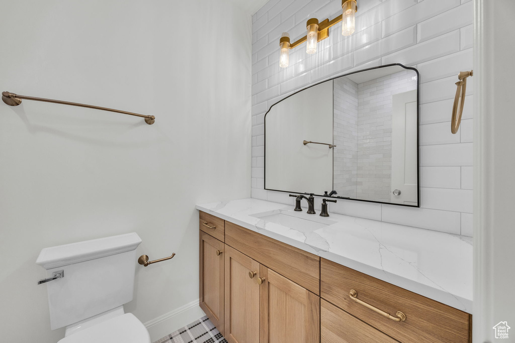 Bathroom with toilet, vanity, and baseboards