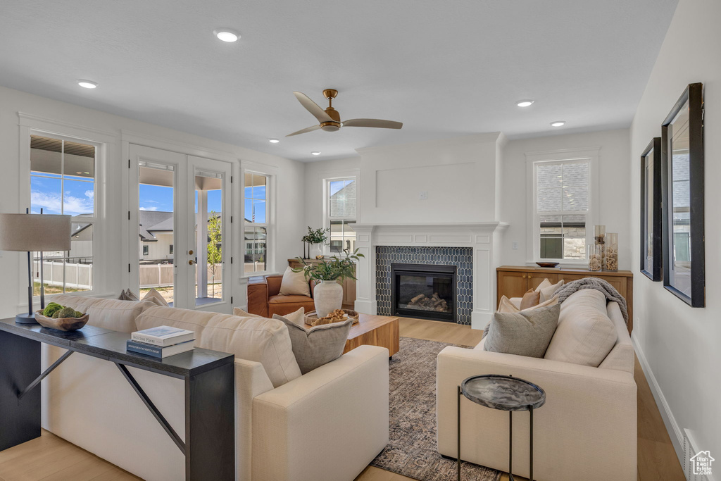 Living area featuring light wood finished floors, ceiling fan, french doors, and visible vents