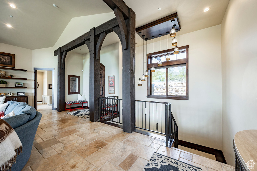 Hall with recessed lighting, stone tile flooring, baseboards, arched walkways, and an upstairs landing