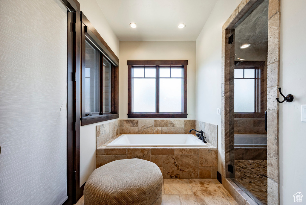 Bathroom featuring a stall shower, a garden tub, and plenty of natural light