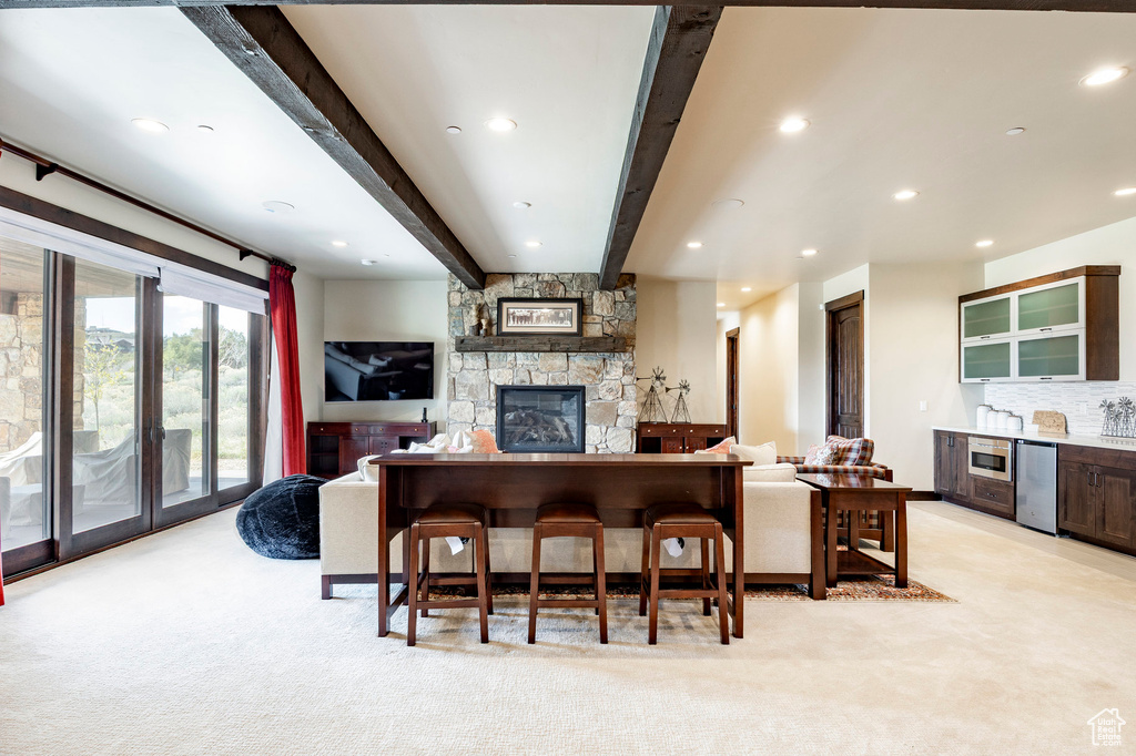Living room with a fireplace, light carpet, beamed ceiling, and recessed lighting