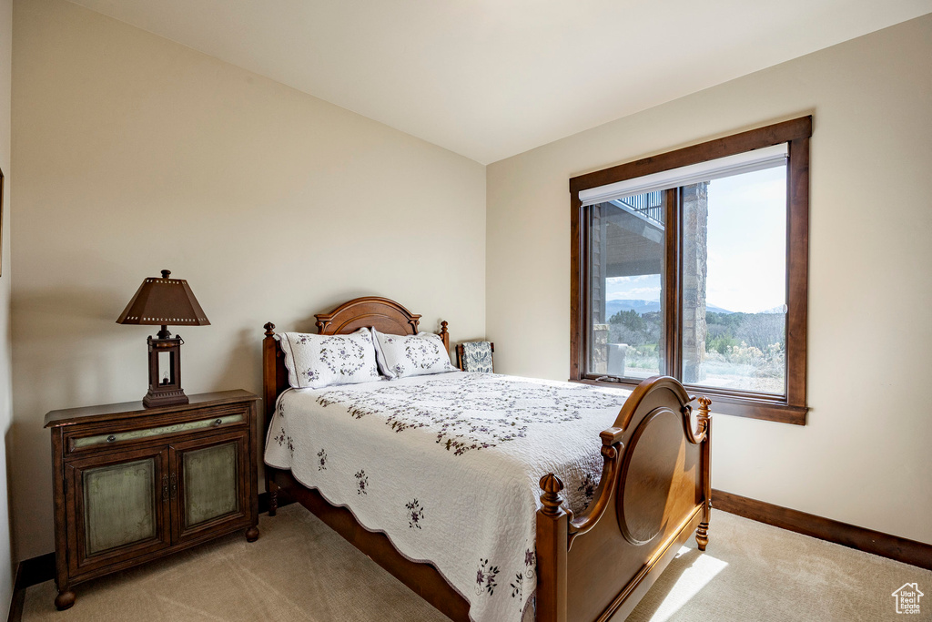 Bedroom with light colored carpet and baseboards