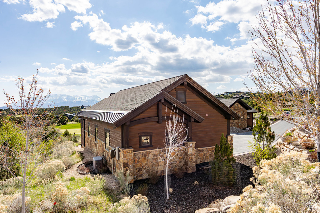 View of side of property with metal roof and stone siding