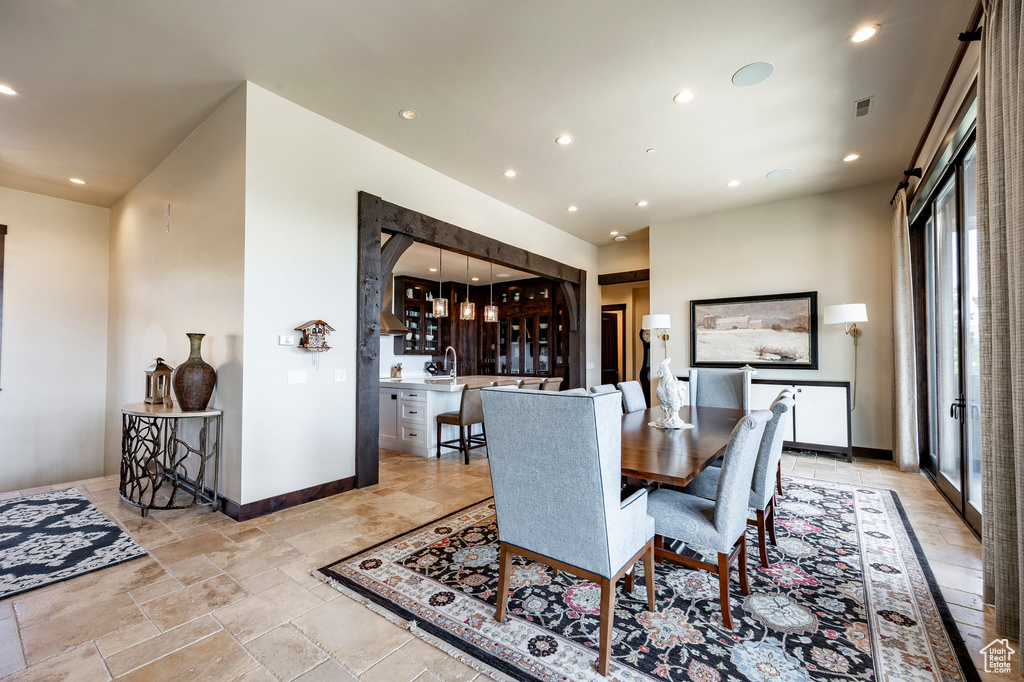 Dining area featuring stone tile floors, baseboards, visible vents, and recessed lighting