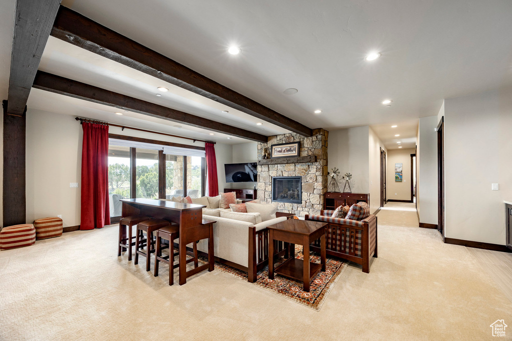 Living room featuring recessed lighting, baseboards, beamed ceiling, a fireplace, and light colored carpet