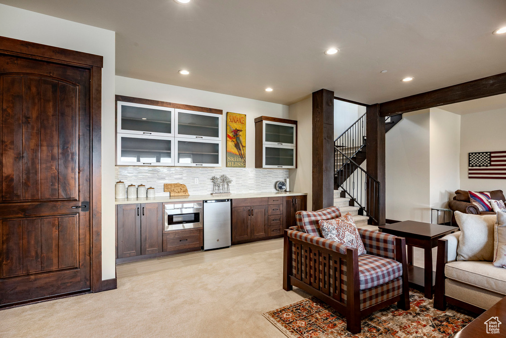 Bar featuring stairs, refrigerator, bar, and recessed lighting