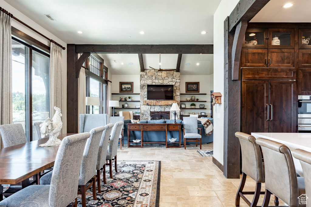 Dining space with recessed lighting, stone tile floors, baseboards, visible vents, and vaulted ceiling with beams