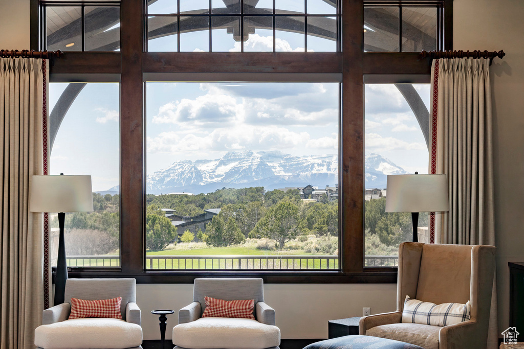 Living area with a mountain view, plenty of natural light, and lofted ceiling