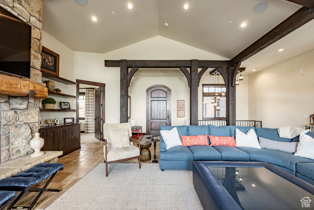 Living area featuring a wealth of natural light, vaulted ceiling, stone tile floors, and recessed lighting