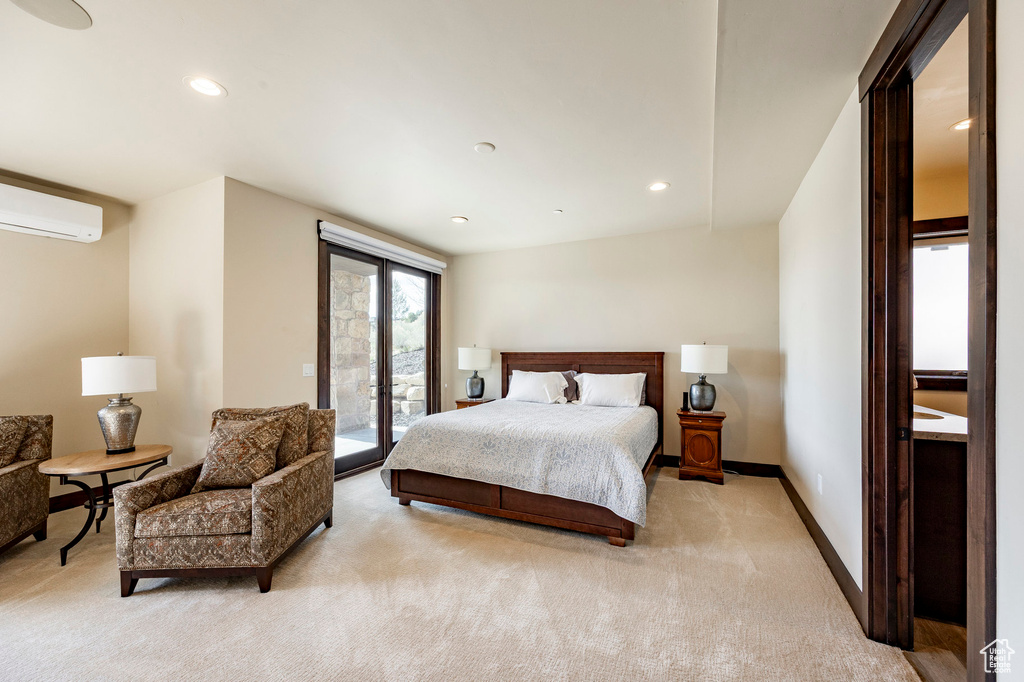 Bedroom featuring recessed lighting, a wall mounted AC, baseboards, light colored carpet, and access to exterior