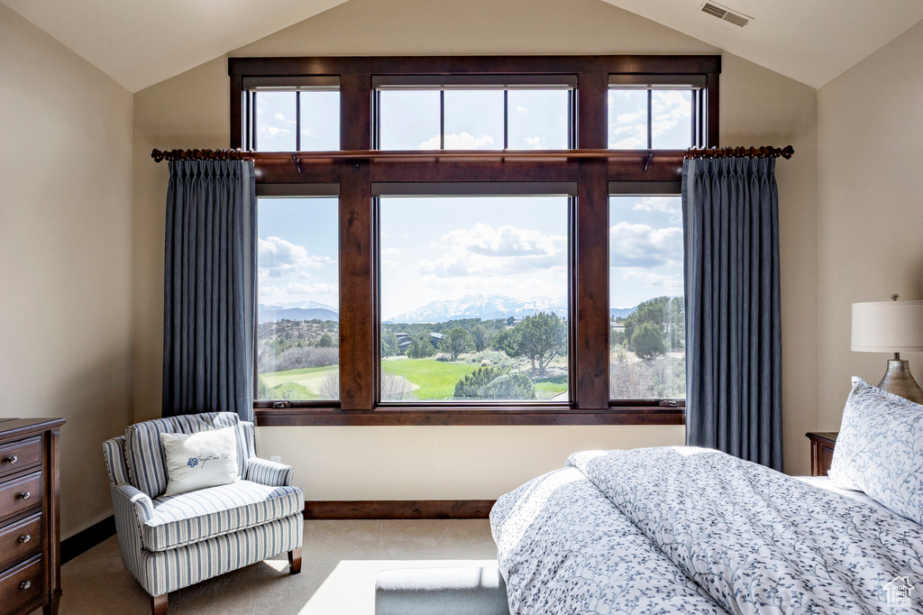 Carpeted bedroom with multiple windows, a mountain view, visible vents, and vaulted ceiling
