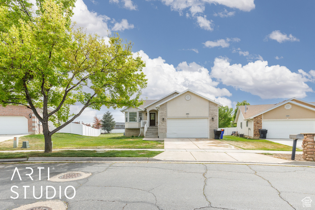 Single story home with concrete driveway, a garage, stucco siding, and a front lawn