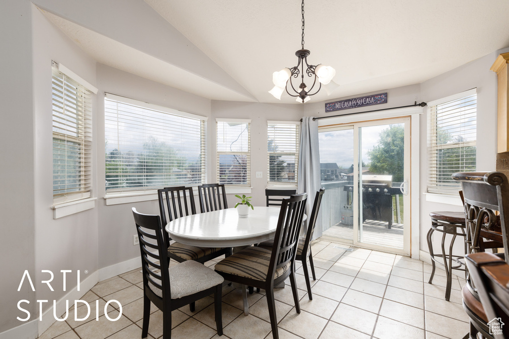 Dining space featuring lofted ceiling, baseboards, a chandelier, and light tile patterned flooring