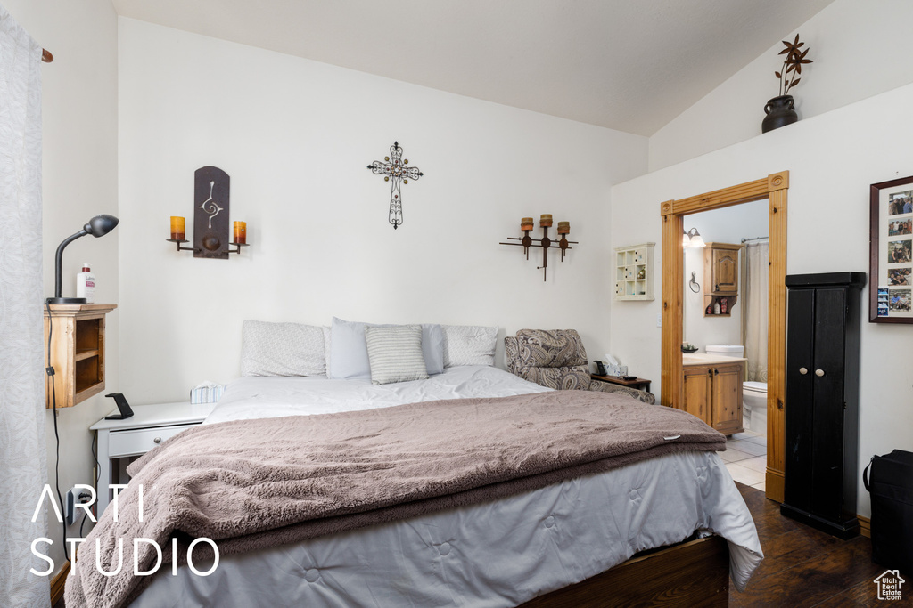 Bedroom featuring lofted ceiling, ensuite bathroom, and wood finished floors