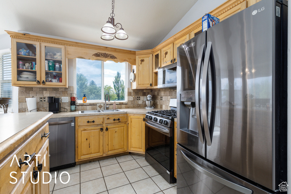 Kitchen featuring light tile patterned floors, a sink, light countertops, tasteful backsplash, and appliances with stainless steel finishes