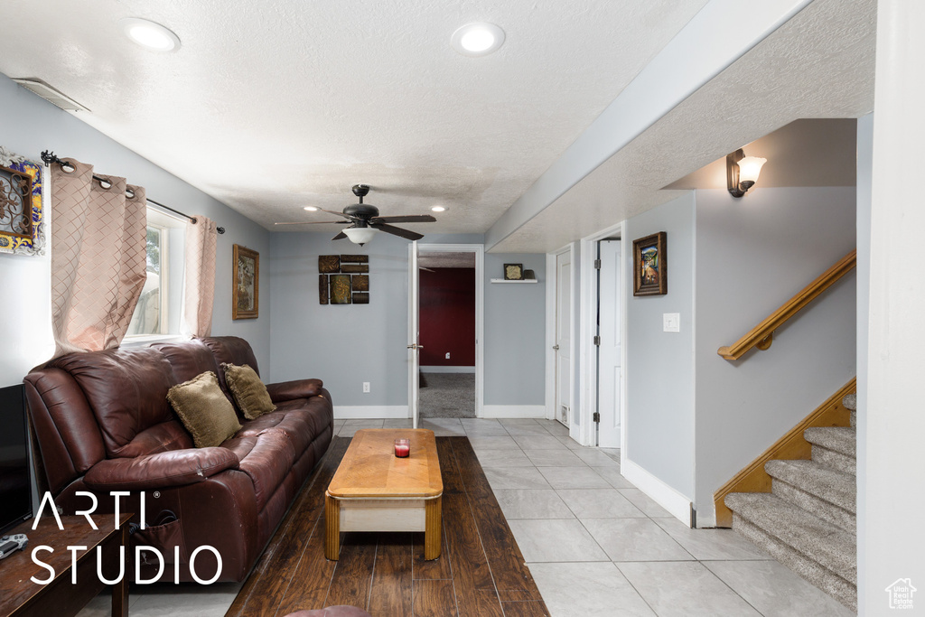 Living area with stairway, ceiling fan, baseboards, and recessed lighting