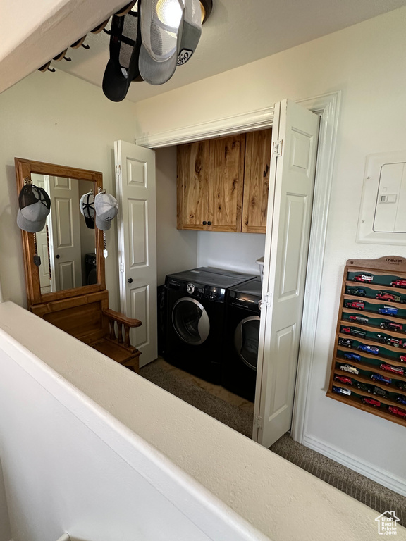 Clothes washing area featuring independent washer and dryer, cabinet space, and electric panel