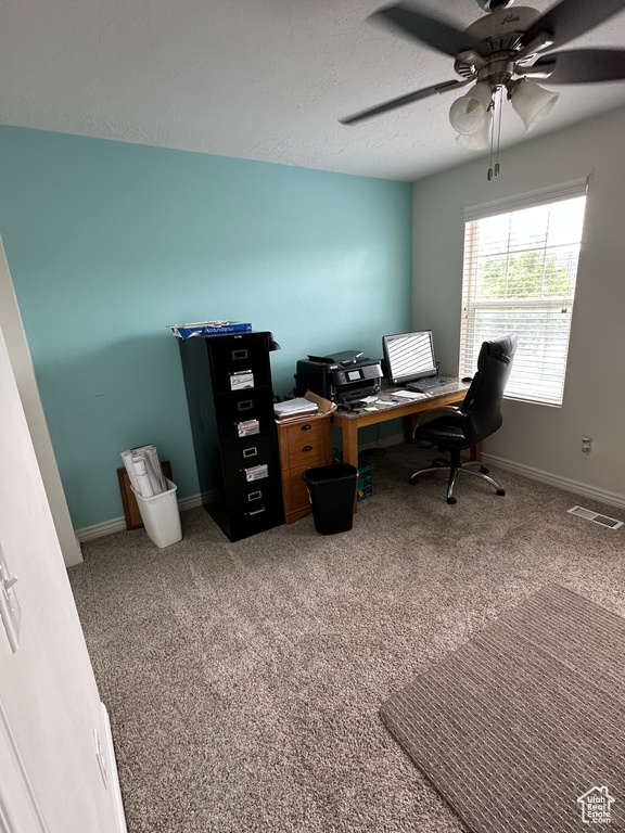 Office area featuring a textured ceiling, visible vents, carpet floors, a ceiling fan, and baseboards