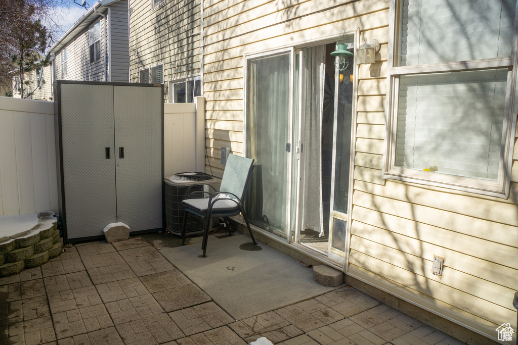 View of patio featuring fence and central AC unit