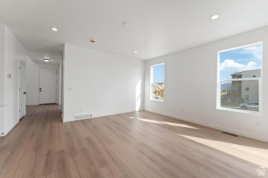 Spare room featuring baseboards, recessed lighting, light wood-style floors, and visible vents
