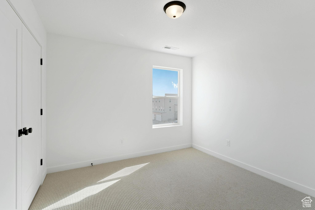 Unfurnished bedroom featuring baseboards, a closet, visible vents, and carpet floors
