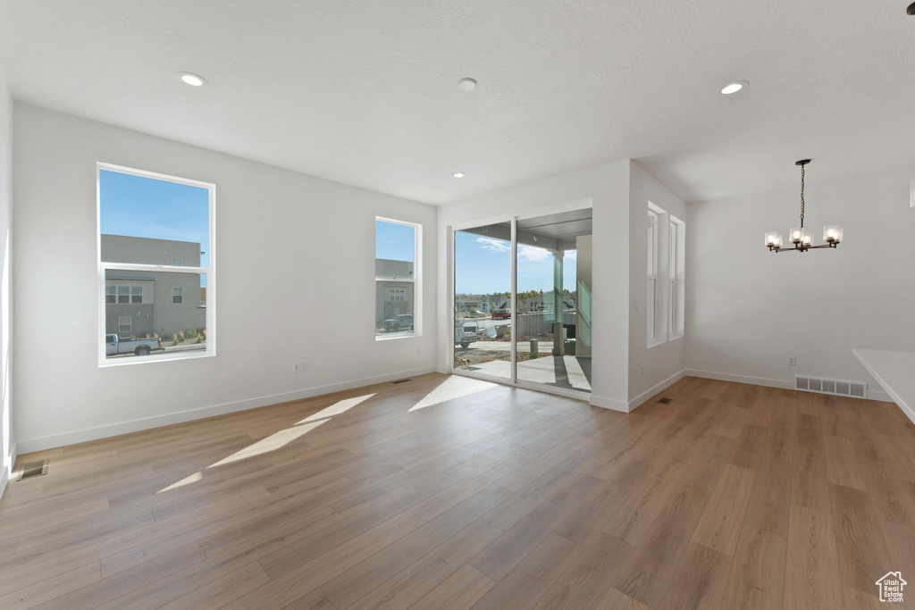 Interior space featuring baseboards, recessed lighting, a notable chandelier, and visible vents