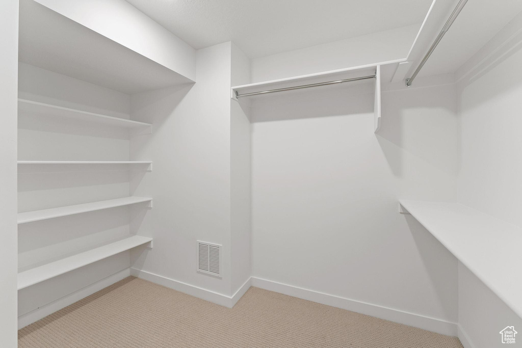 Walk in closet featuring visible vents and carpet floors
