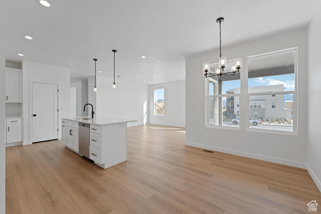 Kitchen featuring recessed lighting, open floor plan, light wood-type flooring, and stainless steel dishwasher