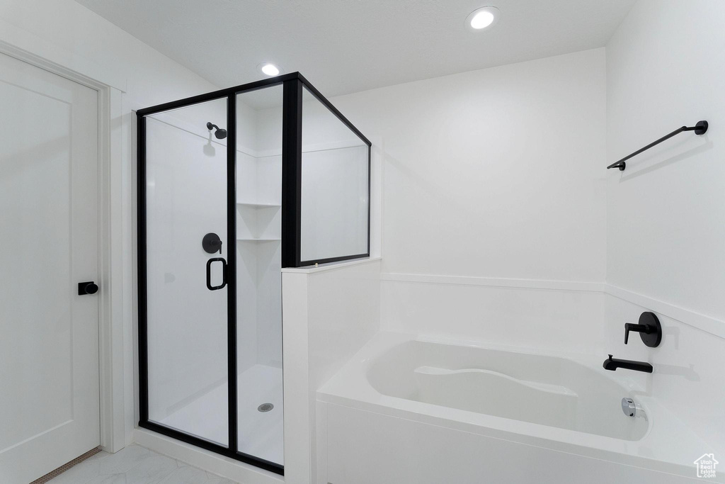 Bathroom with a stall shower, a garden tub, marble finish floor, and recessed lighting