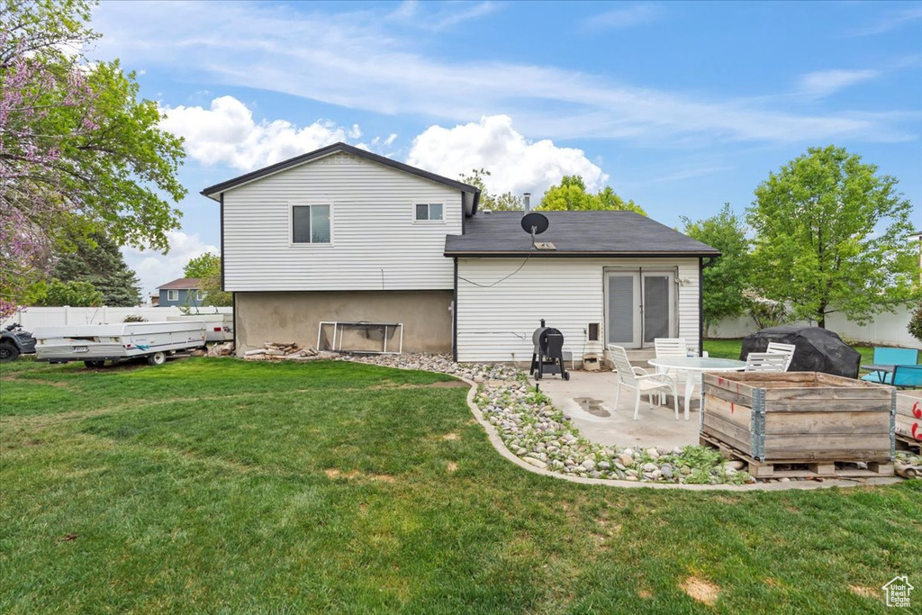 Rear view of house featuring a yard and a patio