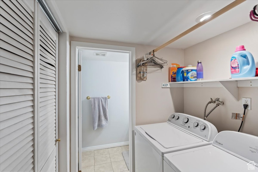 Clothes washing area featuring independent washer and dryer, baseboards, and laundry area