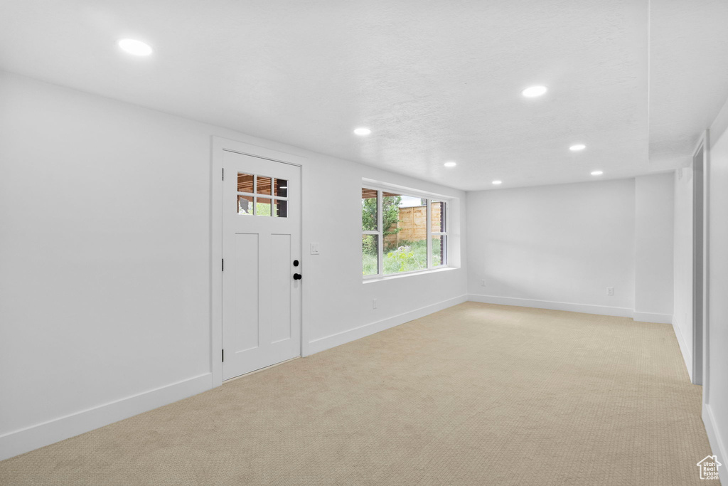Entrance foyer featuring light colored carpet, baseboards, and recessed lighting
